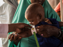 A mother holding her baby at a clinic.