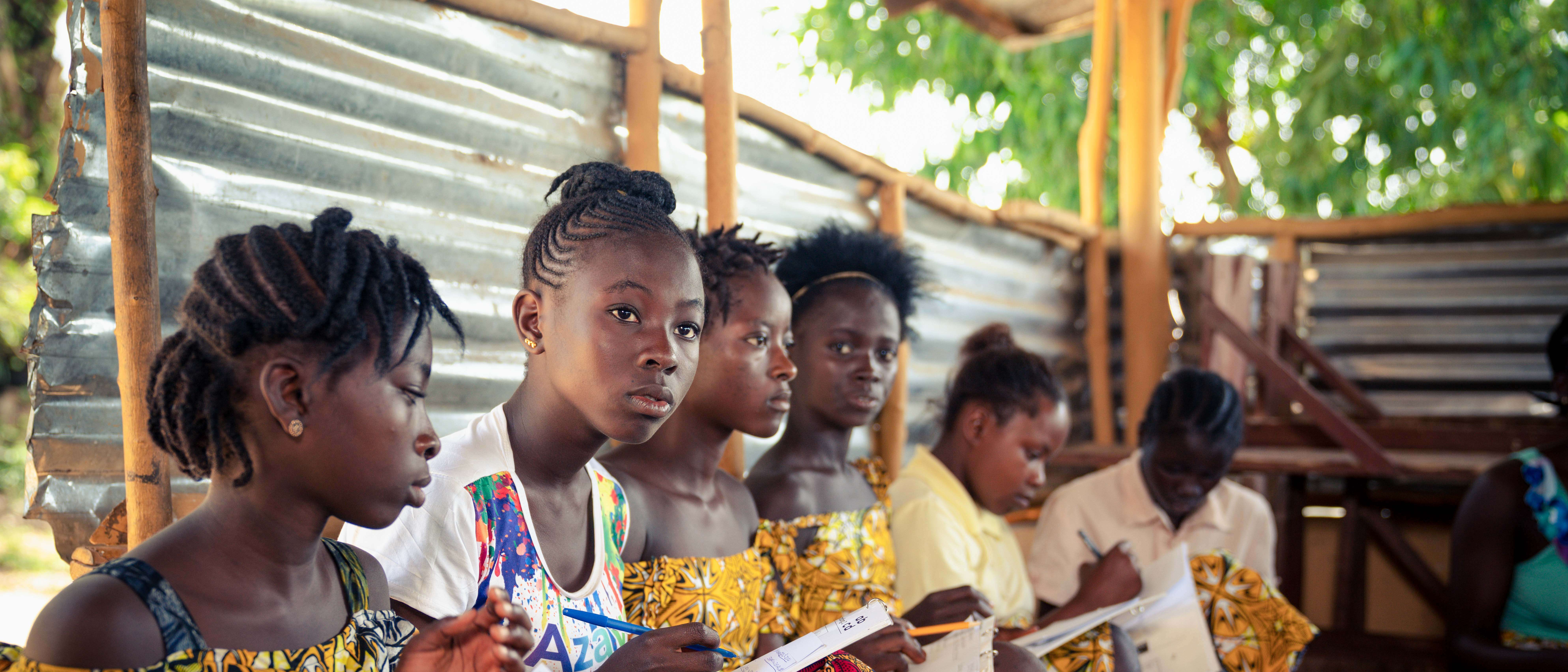 A group of girls take notes during a seminar.